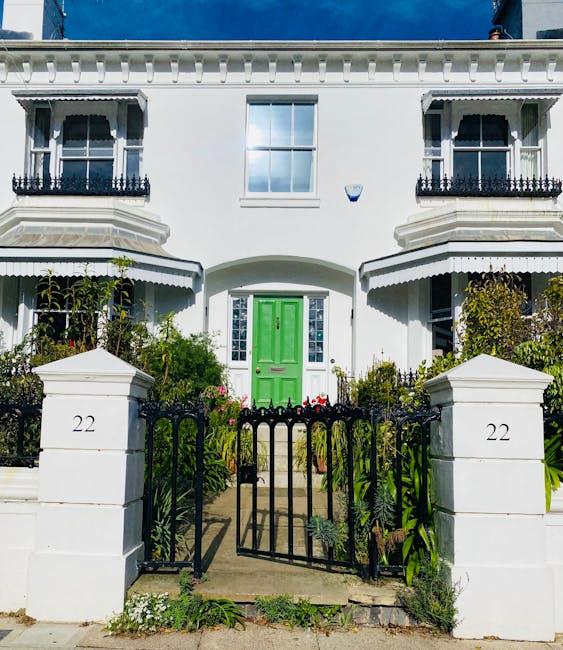 A row of three traditional semi-detached houses situated along a residential street, featuring brick and painted exterior walls, with large bay windows on the ground floor made of white-painted uPVC f
