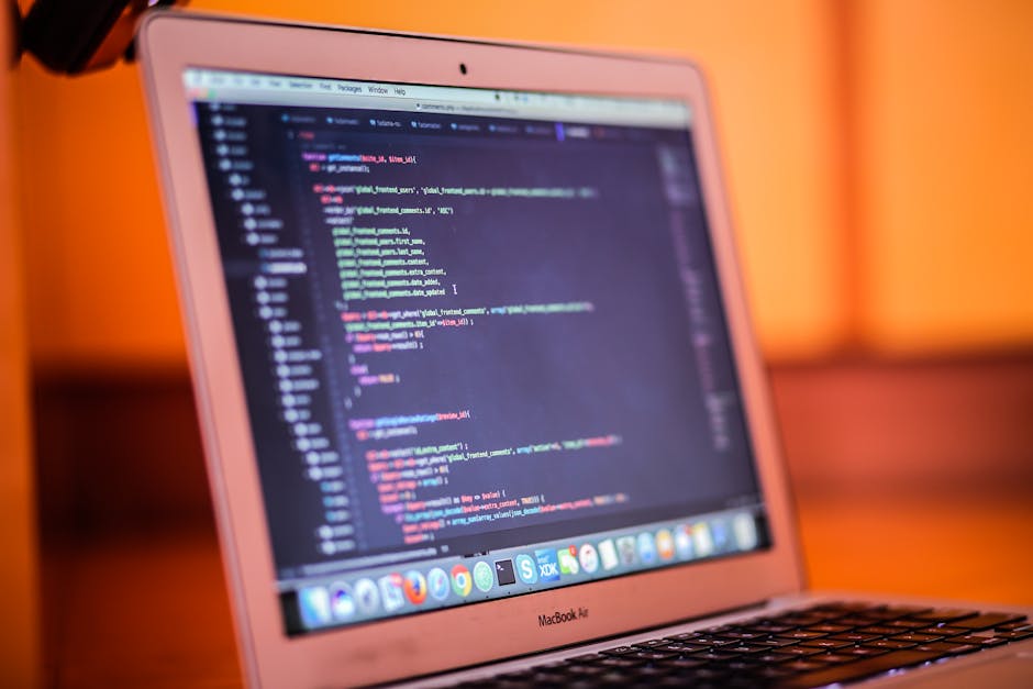 Close-up view of a computer screen displaying lines of HTML code in various colors including blue, yellow, white, and red, with some code snippets referencing images and photo classes. The background
